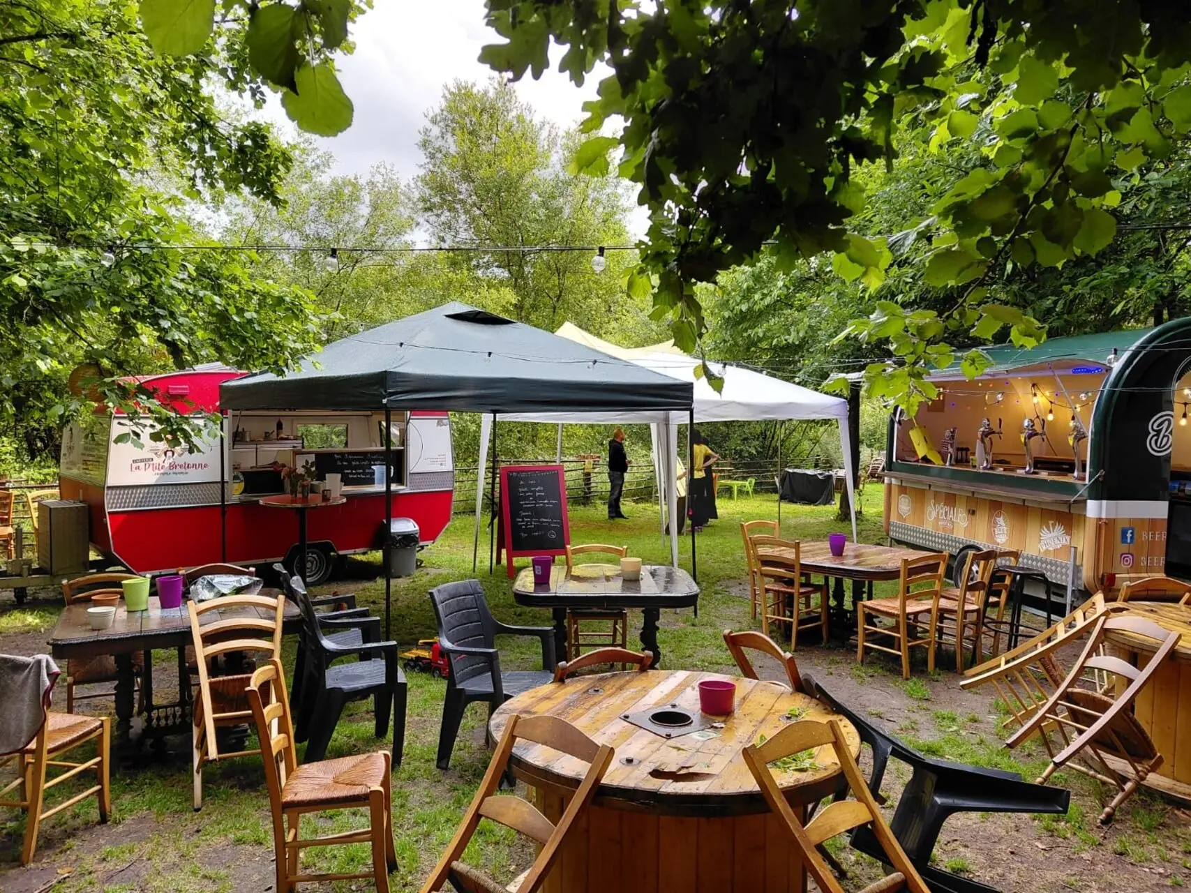 Tables et barnum dressés dans un jardin pour une privatisation du food truck (mariage)